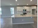 Bright kitchen featuring white cabinets, stainless steel appliances, a large island, and tile flooring at 5318 Center Lake Ranch Blvd, St Cloud, FL 34771