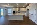 Bright modern kitchen with sleek white cabinetry, stainless steel appliances, and a large center island at 5379 Park Guell St, St Cloud, FL 34771
