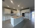 Bright, open kitchen with white cabinets, stainless steel appliances, and an island at 5385 Park Guell St, St Cloud, FL 34771