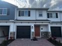Charming two-story townhome featuring a well-manicured brick entryway and a convenient attached garage at 5086 Rain Shadow Dr, St Cloud, FL 34772
