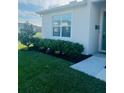 Close-up of front yard featuring green grass, mulch beds, and manicured shrubbery at 2243 Tay Wes Dr, Saint Cloud, FL 34771