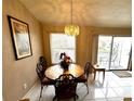 Bright dining room with water view and chandelier at 2520 Woodgate Blvd # 202, Orlando, FL 32822