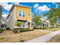 Charming two-story home with bright yellow accents, well-maintained landscaping, and a welcoming entrance at 2736 Bookmark Dr, Kissimmee, FL 34746
