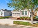 Charming single-Gathering home featuring a decorative garage door, tidy landscaping, and a brick driveway at 349 Alcove Dr, Groveland, FL 34736