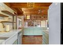The kitchen has painted cabinets, exposed-beam ceilings and an integrated sink at 360 Rest Haven Rd, Geneva, FL 32732