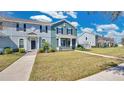 Inviting two-story townhome with a landscaped lawn and covered porch, offering a charming and welcoming exterior at 514 Rainbow Springs Loop, Groveland, FL 34736