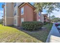 Side view of condo building showcasing landscaping and walkway at 5512 Metrowest Blvd # 110, Orlando, FL 32811