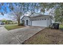 Side view of house with driveway and landscaping at 6621 Bouganvillea Crescent Dr, Orlando, FL 32809