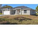 Newly built home features gray siding, a white garage door, and a stone accent wall at 258 Fraser Rd, Debary, FL 32713