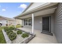 Inviting front porch featuring manicured landscaping and a sleek, modern front door at 4694 Monica St, The Villages, FL 32163