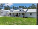 Charming farmhouse with a metal roof, welcoming front porch, and spacious lawn at 12009 Sw 61St Place Road, Ocala, FL 34481