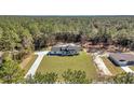 Aerial view of modern farmhouse on a large lot surrounded by lush, dense trees at 8267 Sw 129Th Terrace Rd, Dunnellon, FL 34432