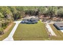 Birds-eye view of a white farmhouse with a long driveway and surrounding green grass at 8267 Sw 129Th Terrace Rd, Dunnellon, FL 34432