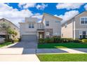 Modern home with gray exterior, stone accents, and a paver driveway at 8956 Hilton Ridge Ave, Kissimmee, FL 34747