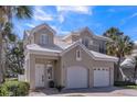 Charming two-story home featuring a two-car garage, neutral stucco siding, and a white tile roof at 7700 Carriage Homes Dr # 4, Orlando, FL 32819