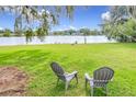 Lush backyard overlooking the lake with relaxing patio chairs at 119 Lake Dr, Oviedo, FL 32765