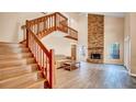 Bright, airy living room with wood floors, brick fireplace, vaulted ceiling, and an open staircase leading to the second floor at 1000 Manigan Ave, Oviedo, FL 32765