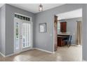 Inviting foyer with tile floors, a modern light fixture, and a view into the adjacent kitchen at 2129 Victoria Glen Dr, Sanford, FL 32773