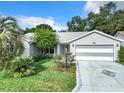 Gray house with a two-car garage and well-manicured lawn at 3904 Plantation Blvd, Leesburg, FL 34748