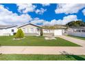 Ranch-style house featuring a well-manicured lawn and driveway at 7659 Nolton Way, Orlando, FL 32822