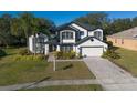 Two-story house with black and white exterior, lush landscaping, and a paved driveway at 4431 Rock Hill Loop, Apopka, FL 32712