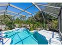 Inviting screened-in pool area with tiled trim, tropical plants and a beautiful water feature at 1269 Buccaneer Ave, Deltona, FL 32725