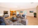 Open living room area with gray furniture and a view of the eat-in kitchen at 516 Yellow Tail Pl, Chuluota, FL 32766