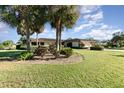 View of the house from the side, showcasing the landscaping and palm trees at 10 Pilot Pl, Winter Haven, FL 33881