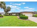 Charming one-story home with mature palm trees, manicured landscaping, and a brick-paved driveway at 10 Pilot Pl, Winter Haven, FL 33881