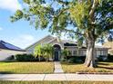 Charming single-story home with a well-manicured lawn and mature trees in a sunny neighborhood at 12924 Lower River Blvd, Orlando, FL 32828