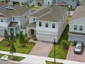 A beautiful neighborhood view shows the home's manicured lawn and brick driveway, and two-car garage at 1162 Happy Forest Loop, Deland, FL 32720