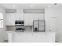 Modern kitchen featuring stainless steel appliances, sleek white cabinets, and a stylish tiled backsplash at 1162 Happy Forest Loop, Deland, FL 32720