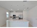 Modern kitchen with white cabinets, stainless steel appliances, a kitchen island and recessed lighting at 1162 Happy Forest Loop, Deland, FL 32720