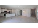 Open-concept living room featuring light-colored tile flooring, and a kitchen with stainless steel appliances at 1162 Happy Forest Loop, Deland, FL 32720