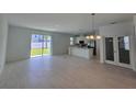 Bright living room with tile floors, stainless steel kitchen appliances, and sliding doors leading to the backyard at 1162 Happy Forest Loop, Deland, FL 32720