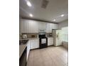 Well-lit kitchen featuring white cabinetry, a black oven range, and stainless-steel sink at 3660 Wilshire Way Rd # 260, Orlando, FL 32829