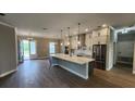 Spacious kitchen featuring an island with pendant lighting and stainless steel appliances and wood-look tile floors at 0 Oberly Pkwy, Orlando, FL 32833