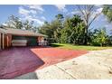 Large backyard with a partially paved area and mature trees at 4028 Wendy Dr, Orlando, FL 32808