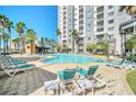 Resort-style pool area with lounge chairs and tropical palm trees for relaxation and enjoyment at 7383 Universal Blvd # 512, Orlando, FL 32819