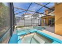 Screened in patio with private pool and connected hot tub, next to a set of patio furniture for lounging at 2948 Banana Palm Dr, Kissimmee, FL 34747