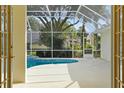 View of the screened-in pool area through open French doors, offering a private outdoor retreat at 349 Plantation Club Dr, Debary, FL 32713