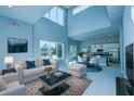 Open-concept living space with soaring ceilings, modern decor, and a seamless flow to the adjacent kitchen and dining area at 7760 Sandy Ridge Dr # 222, Kissimmee, FL 34747