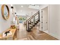 Bright foyer with modern staircase, herringbone wood floors, and views to the living area and outdoor pool at 1606 Hart Ln, Orlando, FL 32804