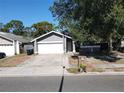 Well-maintained single-story home with a two-car garage, landscaping, and welcoming front entrance at 2212 Atrium Cir, Orlando, FL 32808