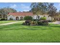 One-story home with red tile roof, manicured lawn, and landscaping at 1000 Dunhurst Ct, Longwood, FL 32779