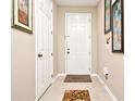 Bright entryway with tile flooring, coat closet, and welcoming mat at 1720 Garden Sage Dr, Oviedo, FL 32765