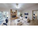 Bright living room featuring a brick fireplace, neutral paint, and plenty of seating at 403 Tranquille Oaks Dr, Ocoee, FL 34761