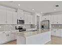 Bright kitchen features white cabinetry, stainless steel appliances, and a large center island with counter seating at 2740 Sweet Acacia Dr, Clermont, FL 34711