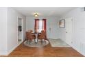 Dining area with a modern table set and view of front door entry and galley kitchen at 2913 Joyann St, Orlando, FL 32810