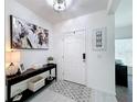 Welcoming foyer featuring light tile floors and a modern console table with stylish decor at 678 Fiddlesticks Dr, Davenport, FL 33837